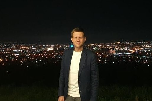 Борис Корчевников позирует на фоне ночного города