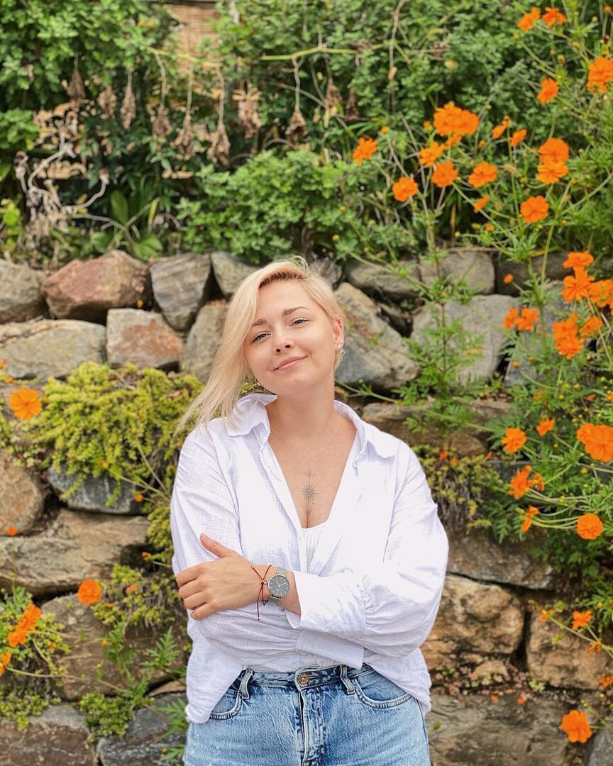 Полина Жигалкина на фоне цветочной изгороди